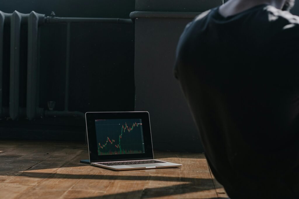 A person observing cryptocurrency trends on a laptop indoors.