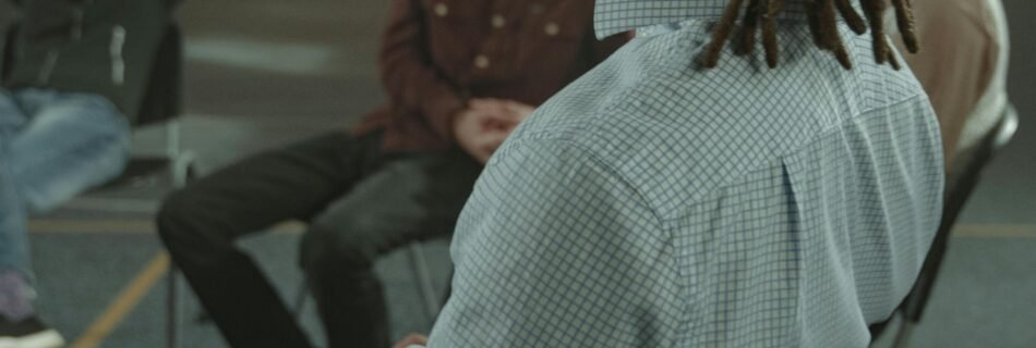 A diverse group of adults engaging in a support therapy session in an indoor setting.