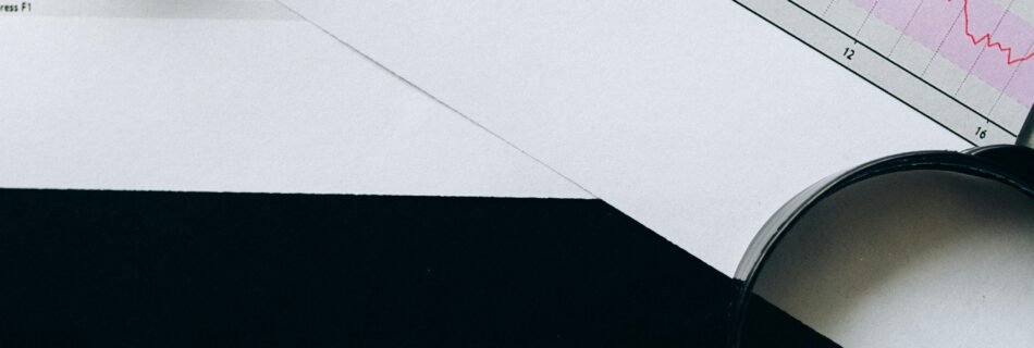 A flat lay image featuring financial charts, highlighters, and dice spelling 'CHANGE' on a black background.